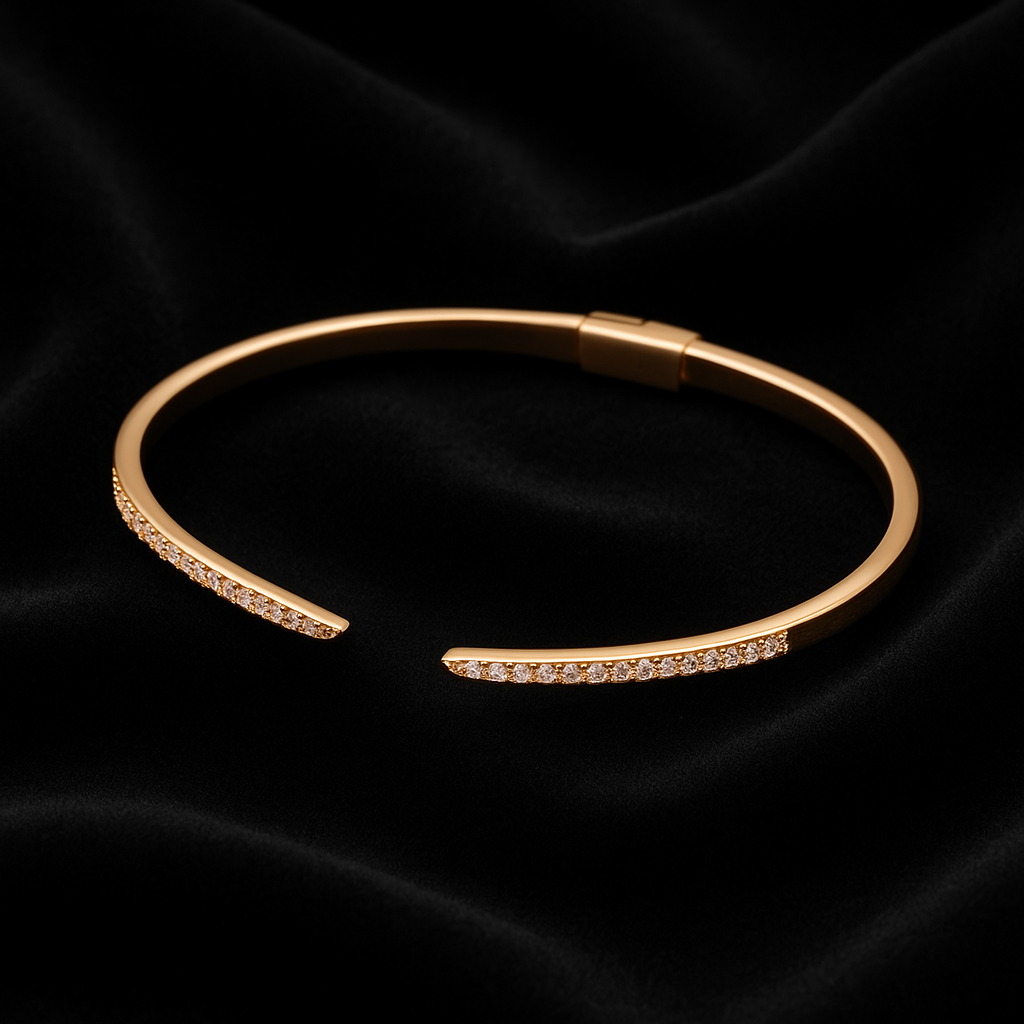 Gold bracelet with small stones on a black satin background
